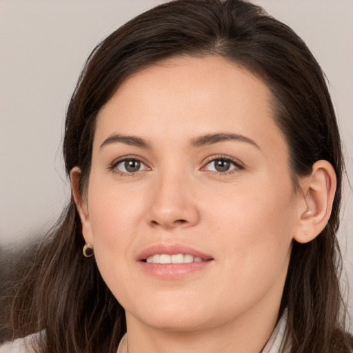 Joyful white young-adult female with long  brown hair and brown eyes