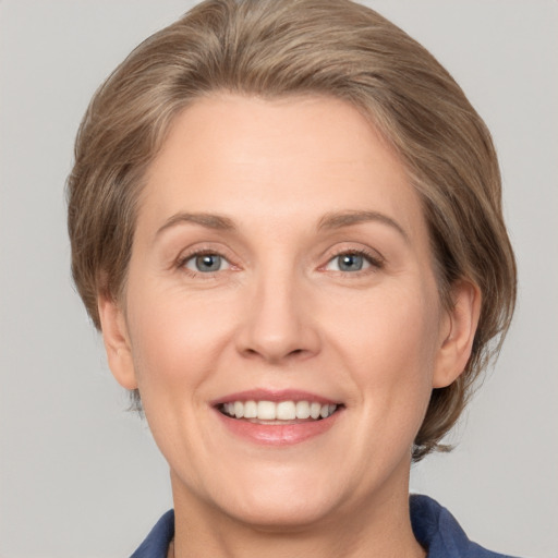 Joyful white adult female with medium  brown hair and grey eyes