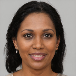 Joyful black adult female with medium  brown hair and brown eyes