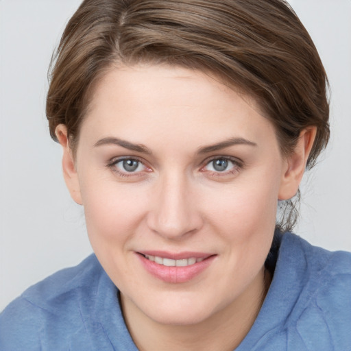 Joyful white young-adult female with medium  brown hair and blue eyes