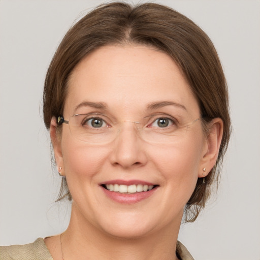 Joyful white adult female with medium  brown hair and grey eyes