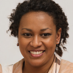 Joyful black young-adult female with long  brown hair and brown eyes