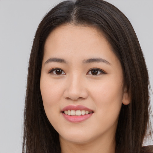 Joyful asian young-adult female with long  brown hair and brown eyes