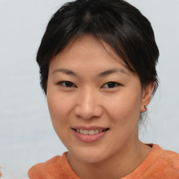 Joyful asian young-adult female with short  brown hair and brown eyes