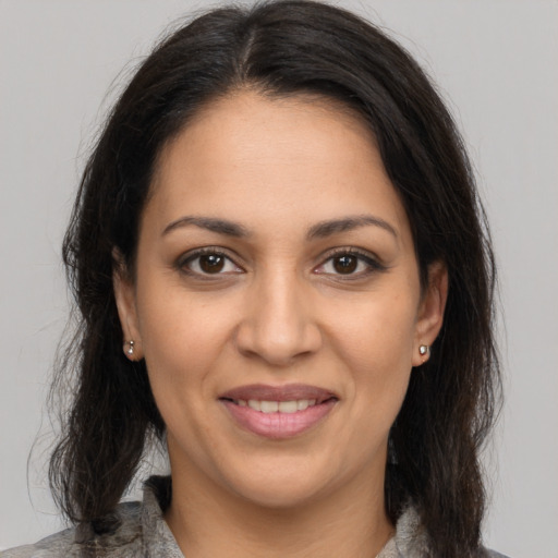 Joyful latino young-adult female with medium  brown hair and brown eyes