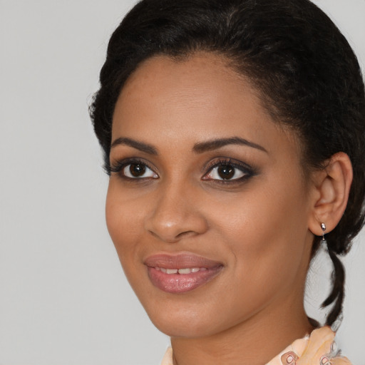 Joyful black young-adult female with medium  brown hair and brown eyes
