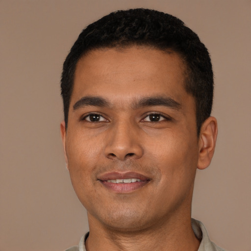 Joyful latino young-adult male with short  black hair and brown eyes