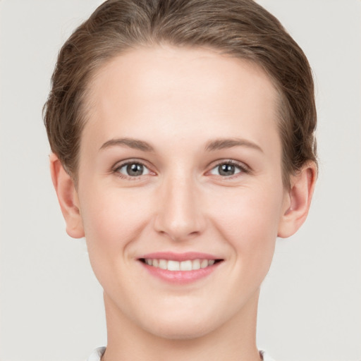 Joyful white young-adult female with short  brown hair and grey eyes