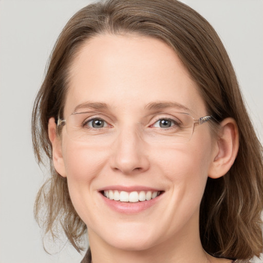 Joyful white adult female with medium  brown hair and grey eyes