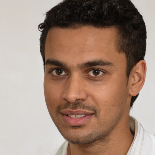 Joyful white young-adult male with short  black hair and brown eyes