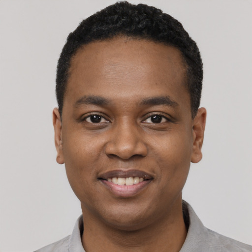 Joyful black young-adult male with short  black hair and brown eyes