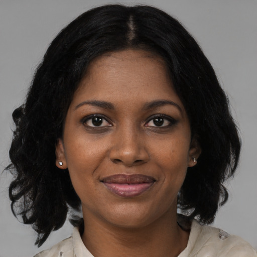 Joyful black young-adult female with medium  black hair and brown eyes