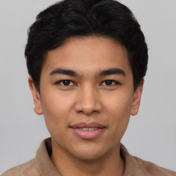 Joyful latino young-adult male with short  brown hair and brown eyes