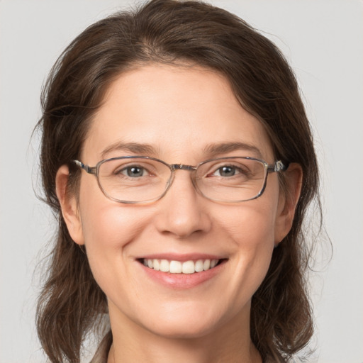 Joyful white adult female with medium  brown hair and grey eyes