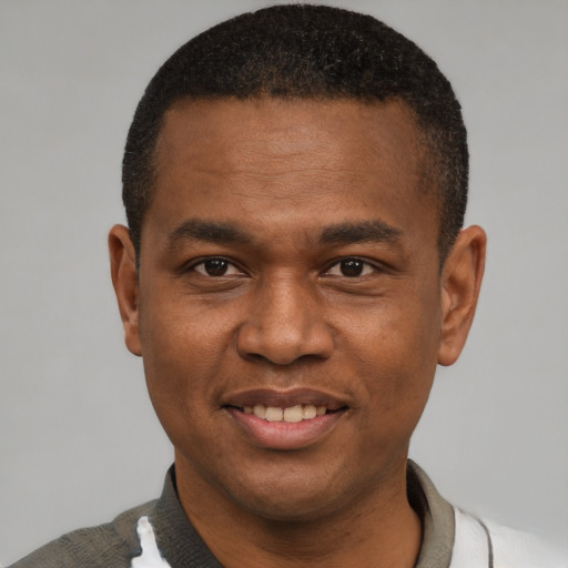 Joyful latino young-adult male with short  brown hair and brown eyes