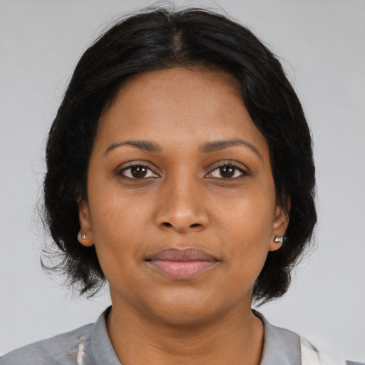 Joyful black young-adult female with medium  brown hair and brown eyes