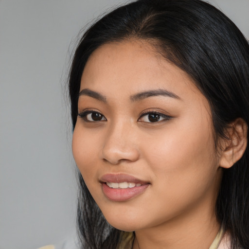 Joyful latino young-adult female with long  black hair and brown eyes