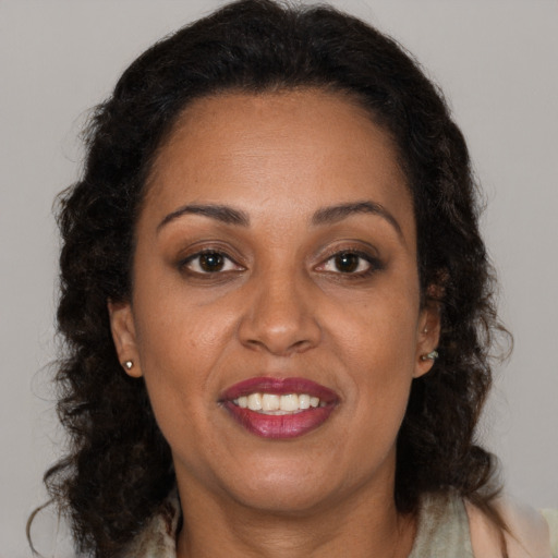 Joyful black adult female with long  brown hair and brown eyes
