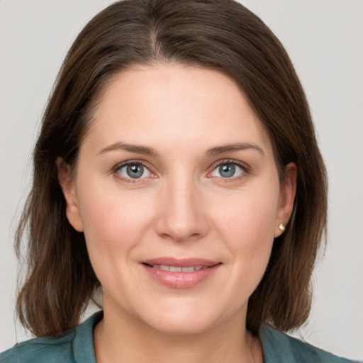 Joyful white young-adult female with medium  brown hair and grey eyes