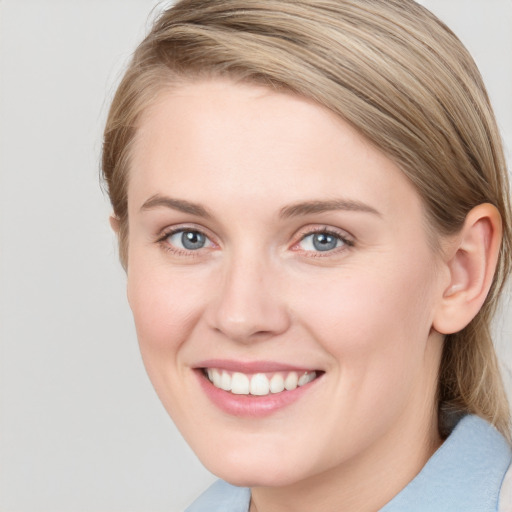 Joyful white young-adult female with medium  brown hair and blue eyes