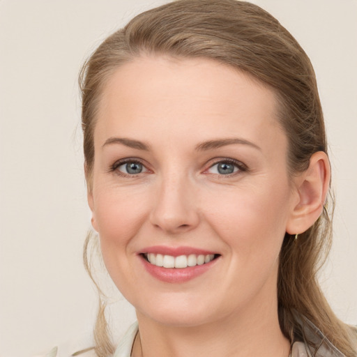 Joyful white young-adult female with long  brown hair and blue eyes