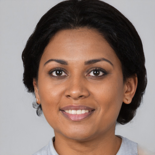 Joyful black young-adult female with medium  brown hair and brown eyes