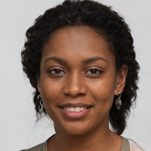 Joyful black young-adult female with long  black hair and brown eyes