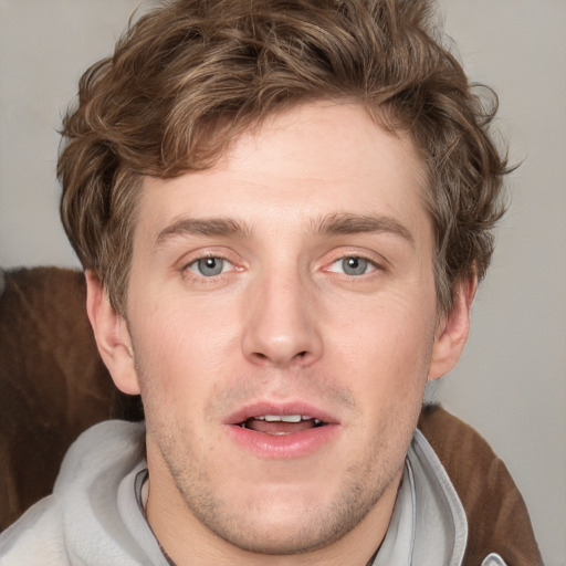 Joyful white young-adult male with short  brown hair and blue eyes