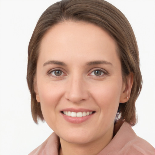 Joyful white young-adult female with medium  brown hair and grey eyes