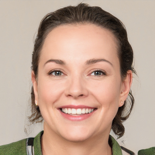 Joyful white young-adult female with medium  brown hair and green eyes