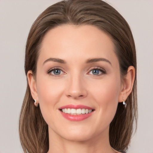 Joyful white young-adult female with medium  brown hair and grey eyes