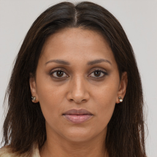 Joyful black adult female with long  brown hair and brown eyes