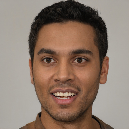 Joyful latino young-adult male with short  black hair and brown eyes