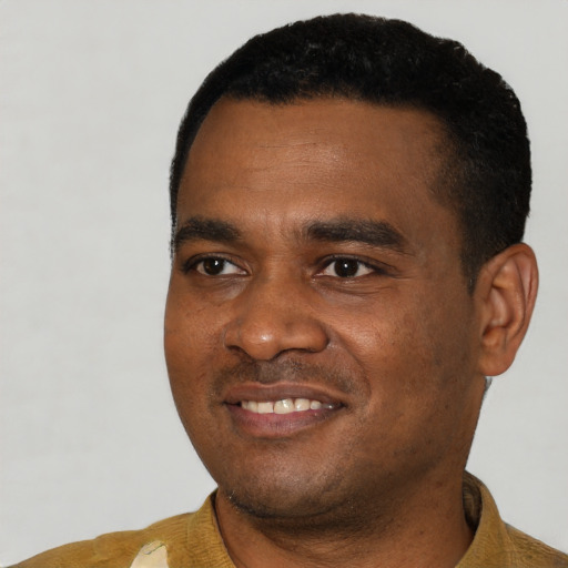 Joyful black young-adult male with short  black hair and brown eyes