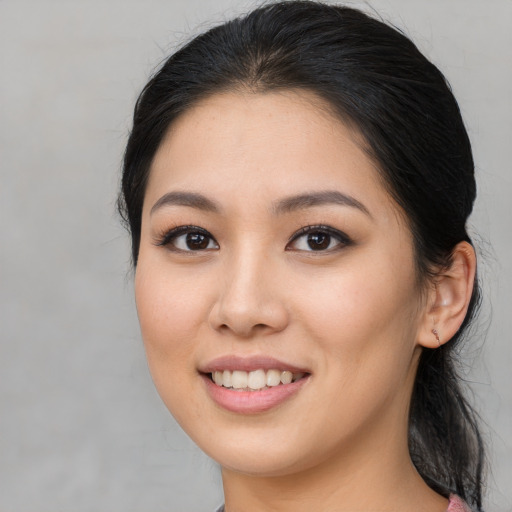 Joyful asian young-adult female with long  brown hair and brown eyes