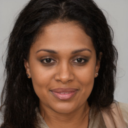 Joyful black young-adult female with long  brown hair and brown eyes