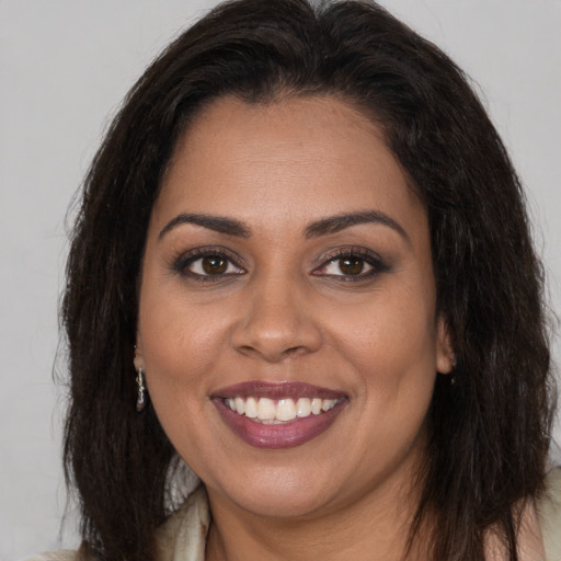Joyful black young-adult female with long  brown hair and brown eyes