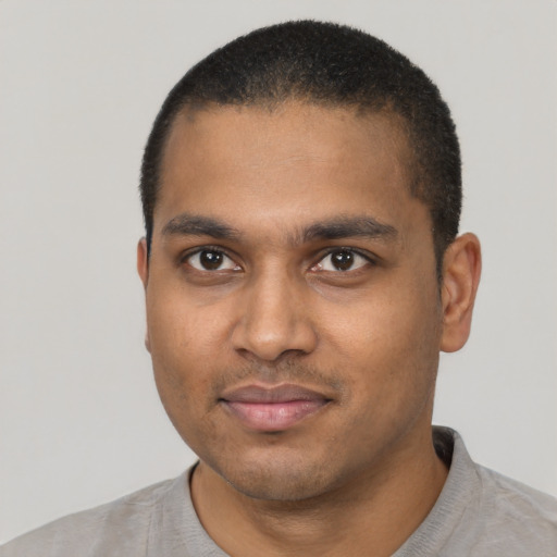 Joyful black young-adult male with short  black hair and brown eyes