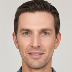 Joyful white young-adult male with short  brown hair and grey eyes