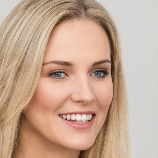 Joyful white young-adult female with long  brown hair and blue eyes