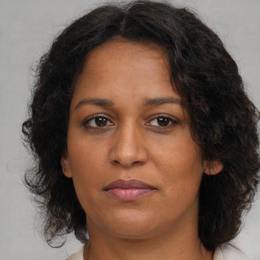 Joyful black adult female with medium  brown hair and brown eyes