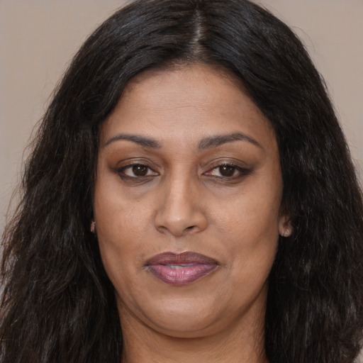 Joyful latino adult female with long  brown hair and brown eyes