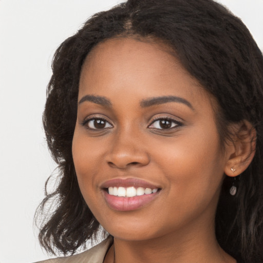 Joyful black young-adult female with long  black hair and brown eyes