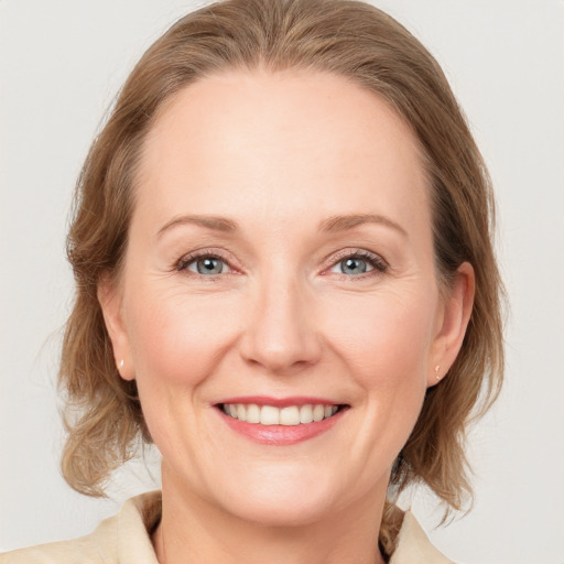 Joyful white adult female with medium  brown hair and blue eyes