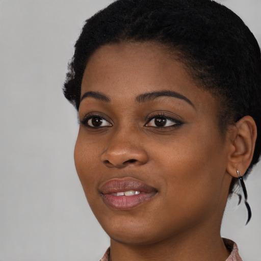 Joyful black young-adult female with short  black hair and brown eyes
