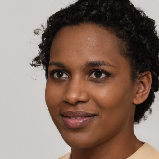 Joyful black young-adult female with short  brown hair and brown eyes