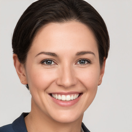 Joyful white young-adult female with short  brown hair and grey eyes