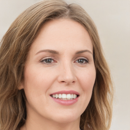 Joyful white young-adult female with long  brown hair and green eyes