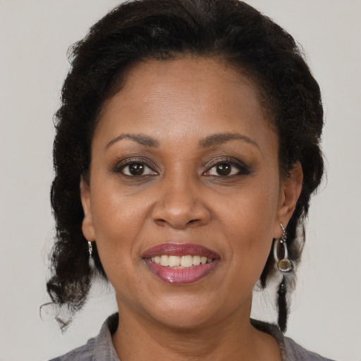 Joyful black adult female with medium  brown hair and brown eyes