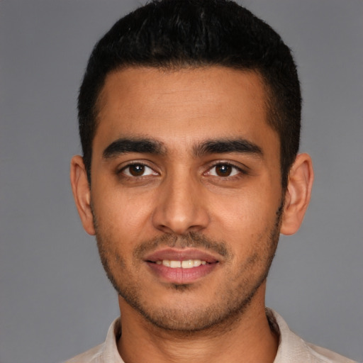 Joyful latino young-adult male with short  black hair and brown eyes